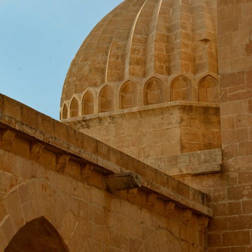 Elegant stone dome with intricate arches in Mardin, Türkiye showcasing historic architecture.